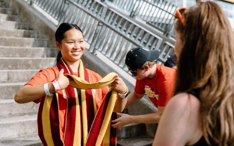 A Gzowksi Orientation leader preparing to scarf a new student.