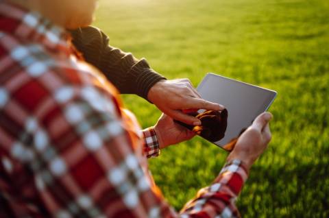 A photo of two older adults using a tablet. 