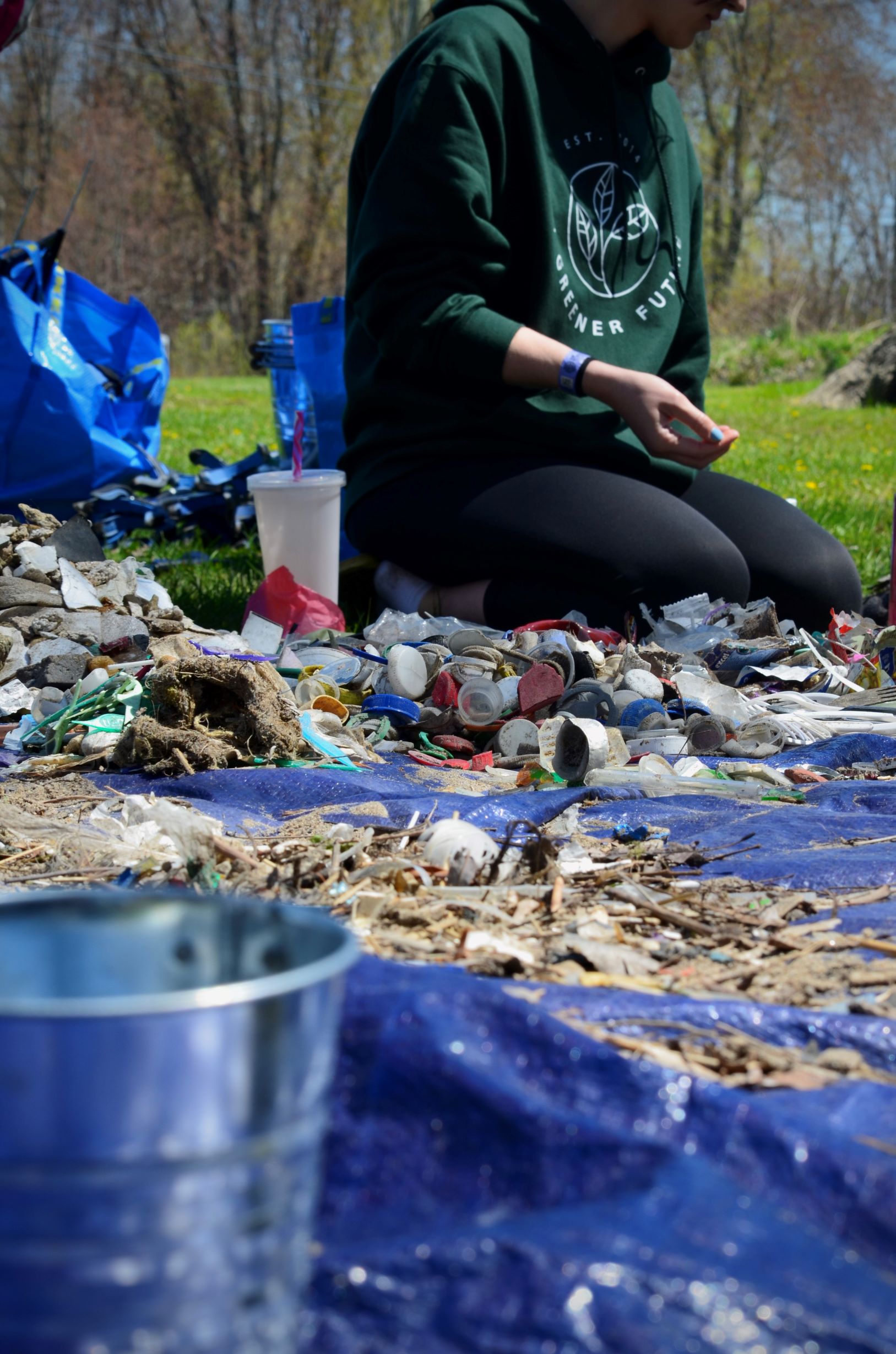 Student sorting garbage on lake shoreline