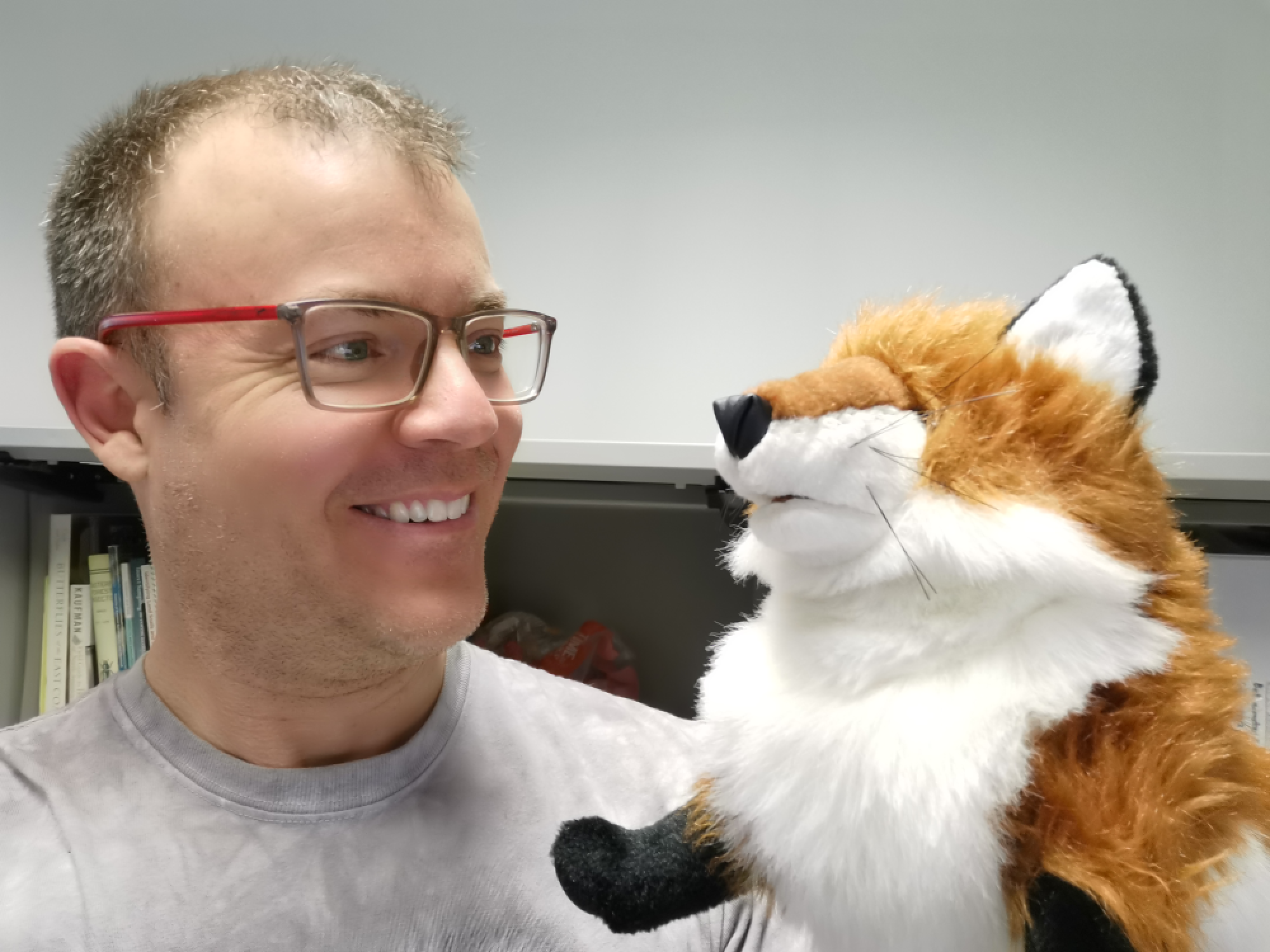 Jay Fitzsimmons holding and looking at a fox puppet 