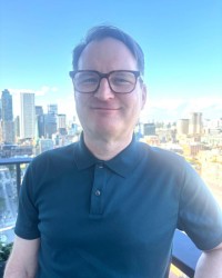 James Penney standing on a balcony with buildings in the background