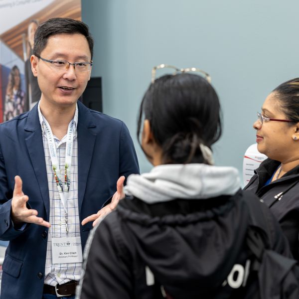 A professor speaking to a future student and their parent