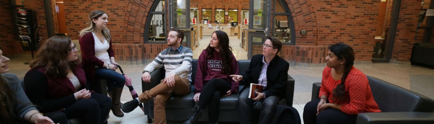 A group of students speaking with a professor 