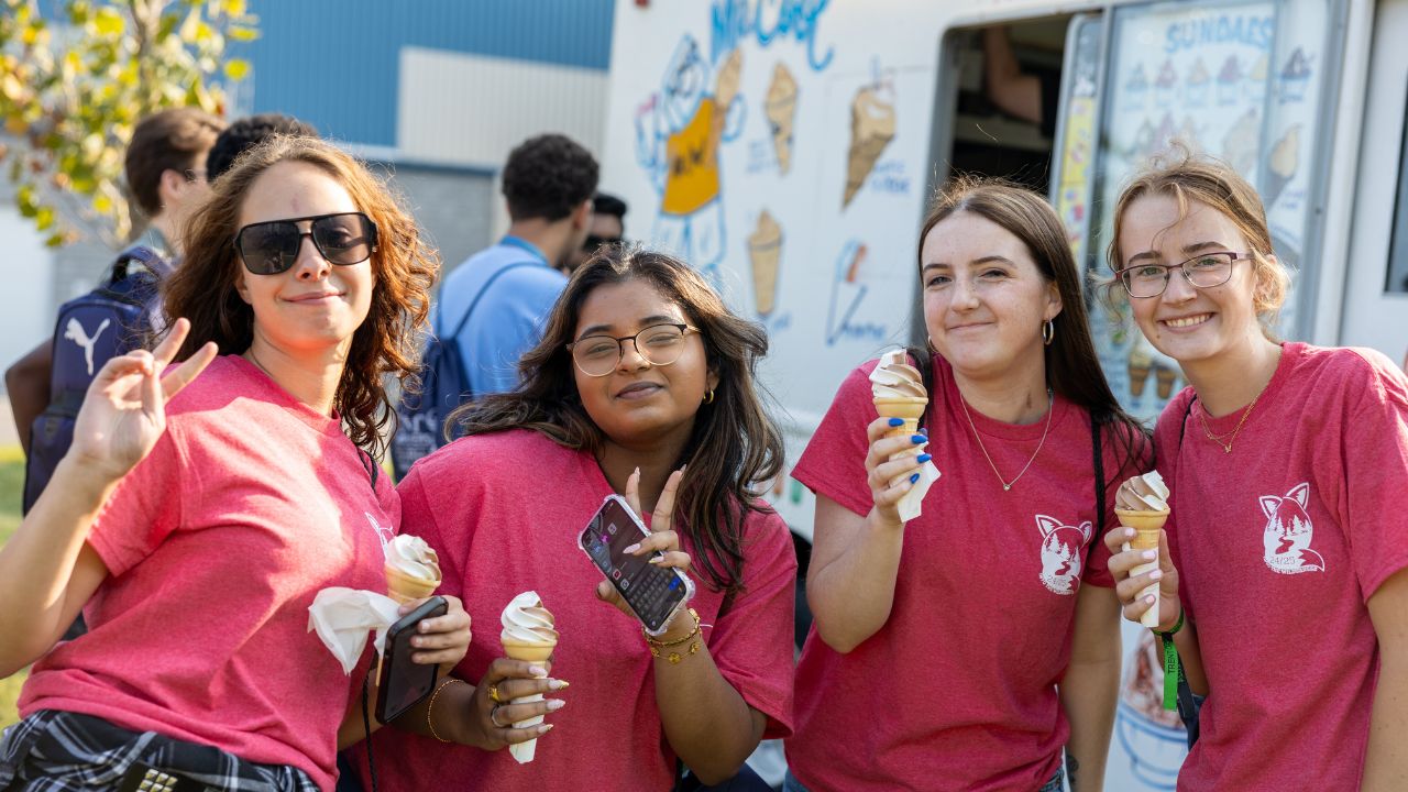 Four students enjoying ice cream cones at an Orientation Week event.