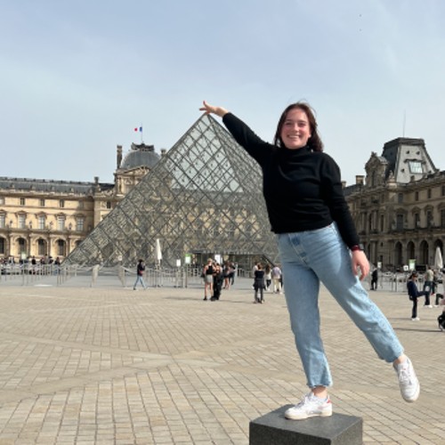 A student posing in front of the Louvre in Paris