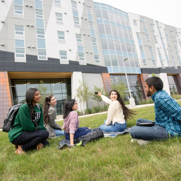 A group of students taking a photo on the lawn