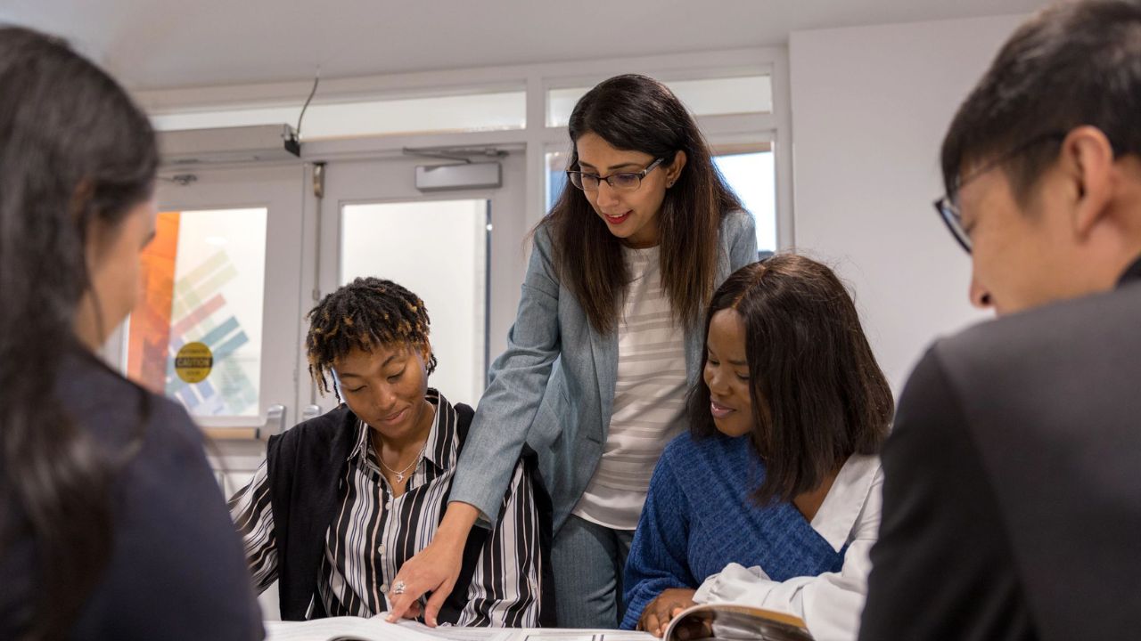 A professor instructing a group of students in a masters of management class