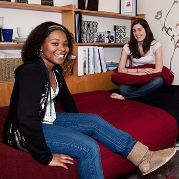 Two students sitting together in a residence room