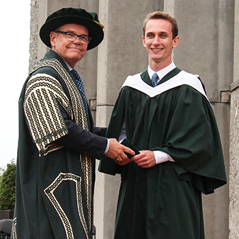 A graduating student being congratulated by the Chancellor