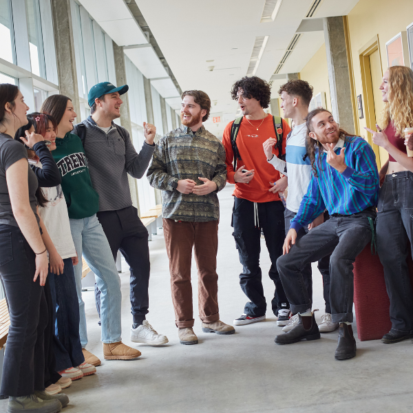 A Group of Trent University students talking to each other in a hallway.