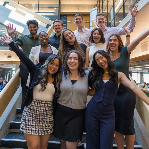 Group of Trent University’s Enrollment Advisors, with their hands in the air, smiling to the camera, in Bata Library.