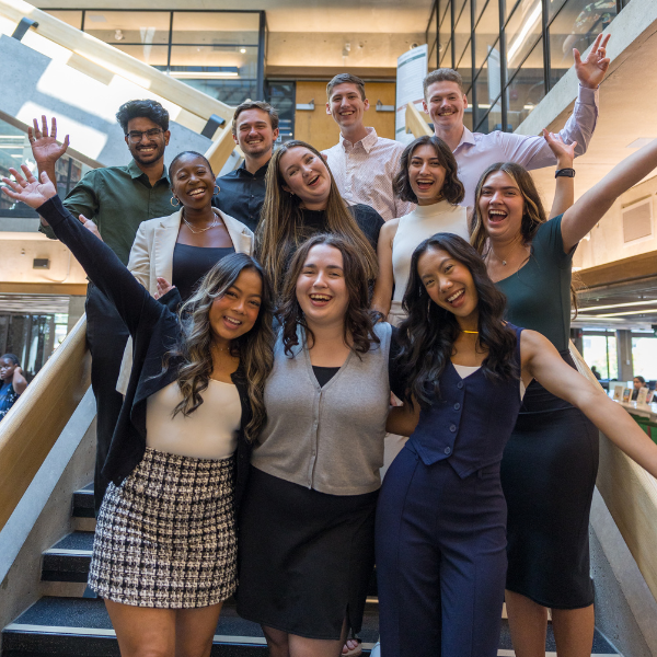 Group of Trent University’s Enrollment Advisors, with their hands in the air, smiling to the camera, in Bata Library.