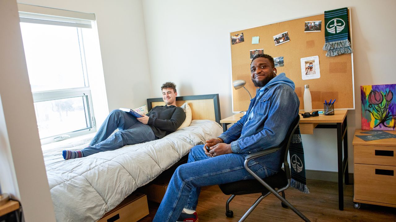 Two male students relaxing in a residence room