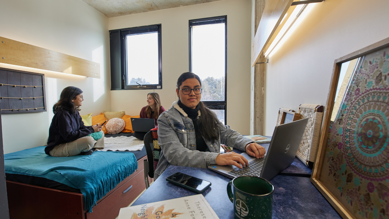 Three female students in a residence room