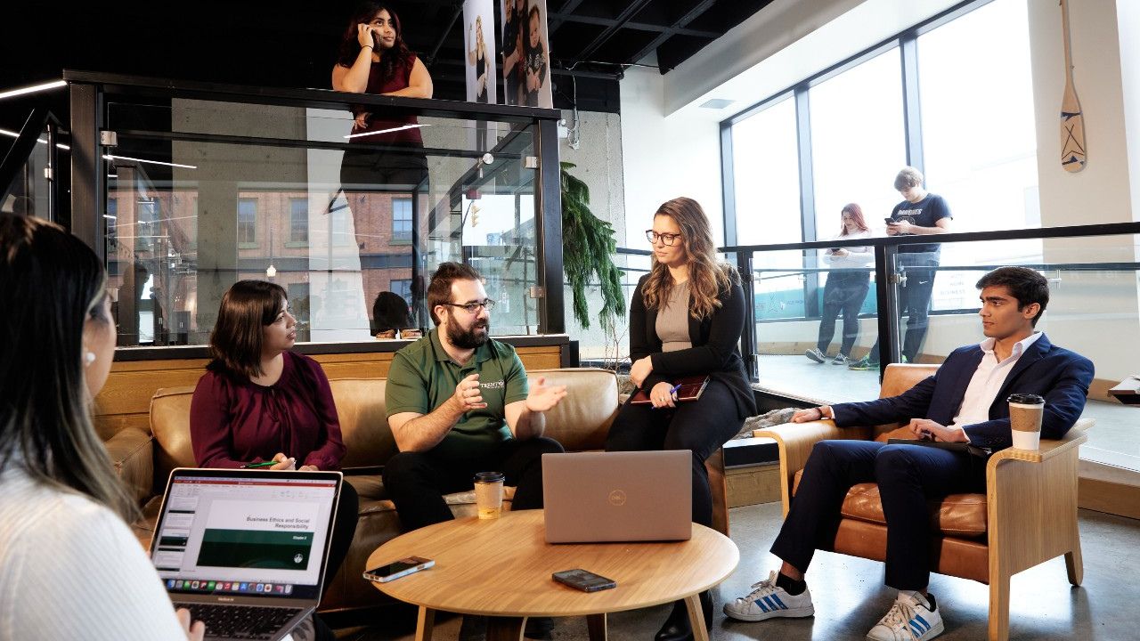 A group of students have a conversation in a lobby.