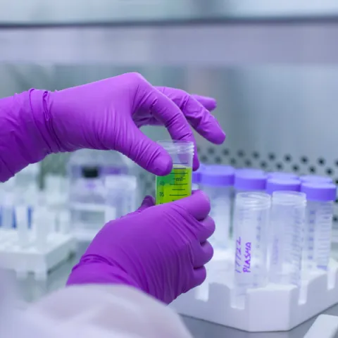 Student in lab handling chemicals.