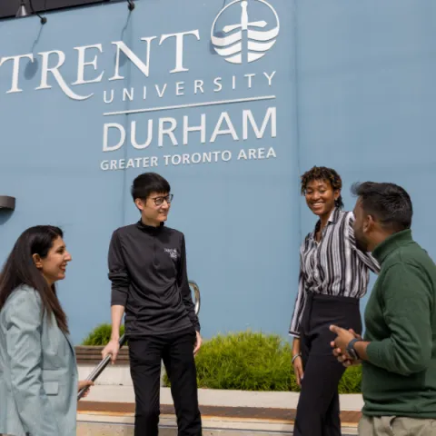 Trent University professor and students talking to each other outside.