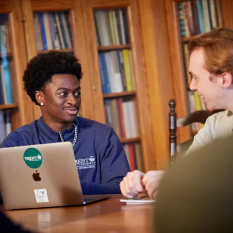 Trent University students working together on a computer.