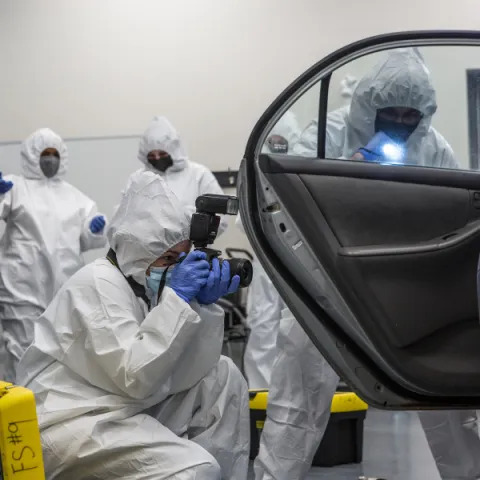 Trent University Forensics science students in lab, taking photo of a car.