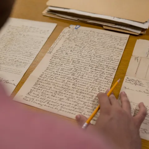 Trent University student looking at archival notes.