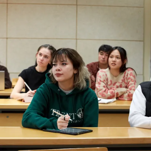 Trent University students, in lecture, listening to professor.