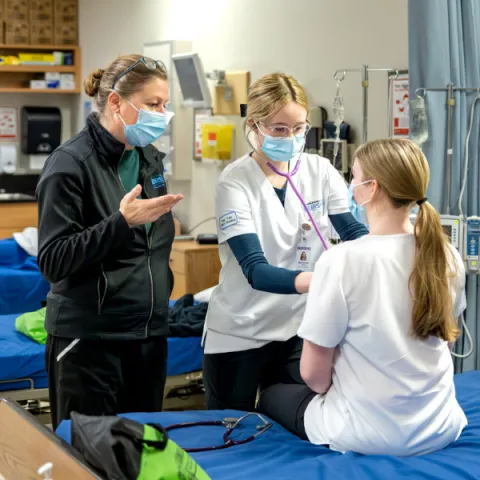 Trent University students in nursing lab, listening to heart beat.