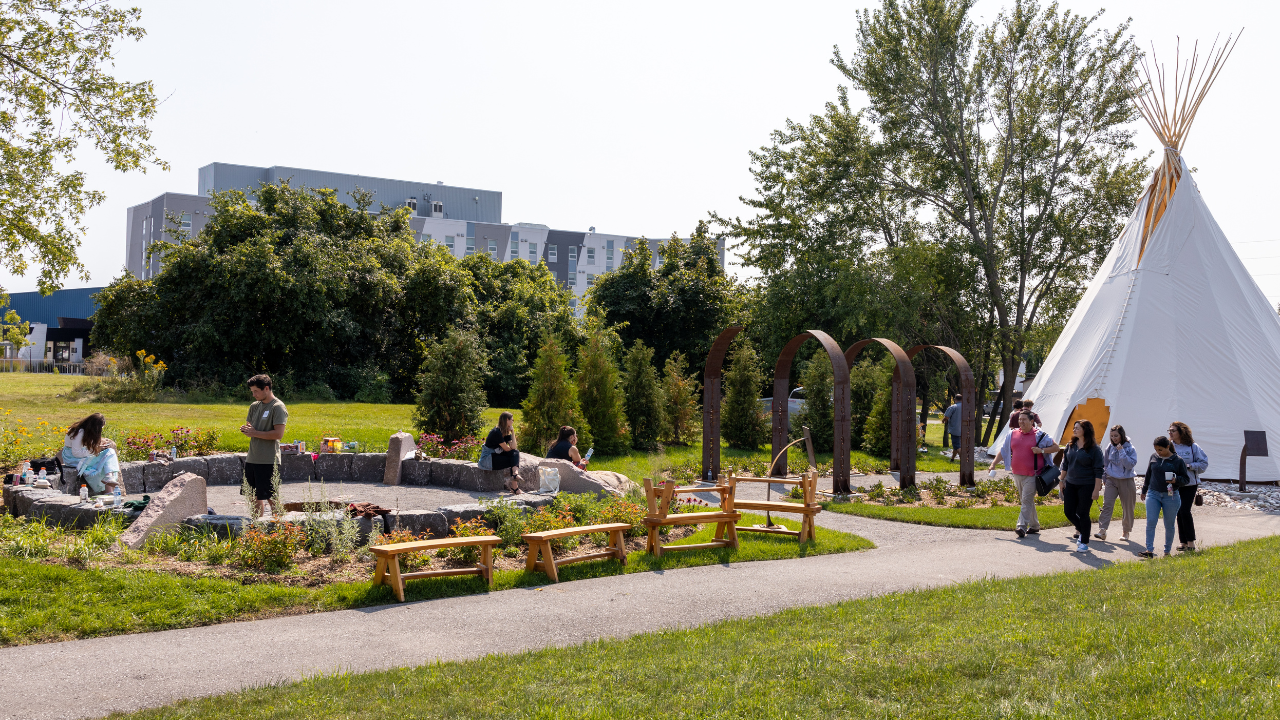 Group of Trent students walking in front of tipi.