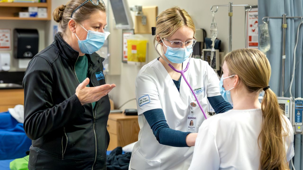 A nursing student practicing on a patient.