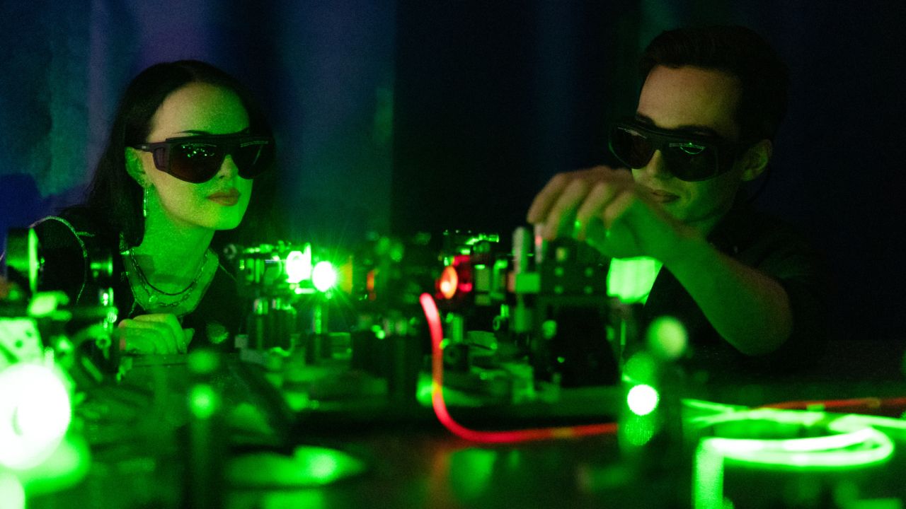 Two students working with green lasers