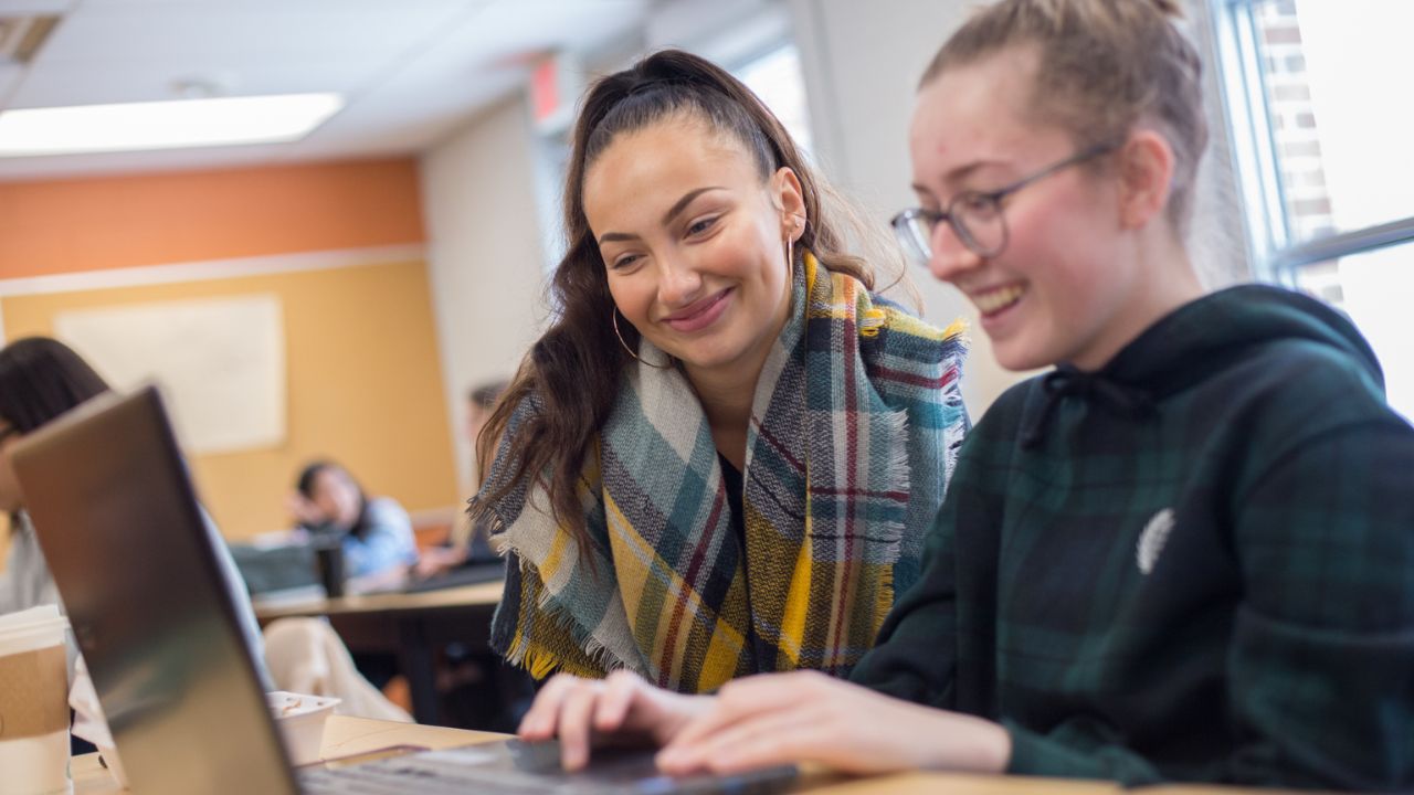 Two students looking at a laptop