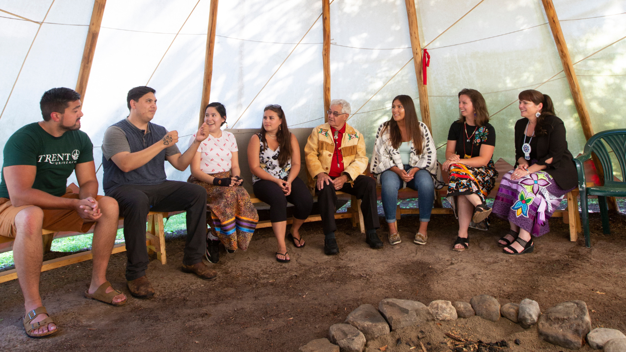 Students and staff inside of tipi.