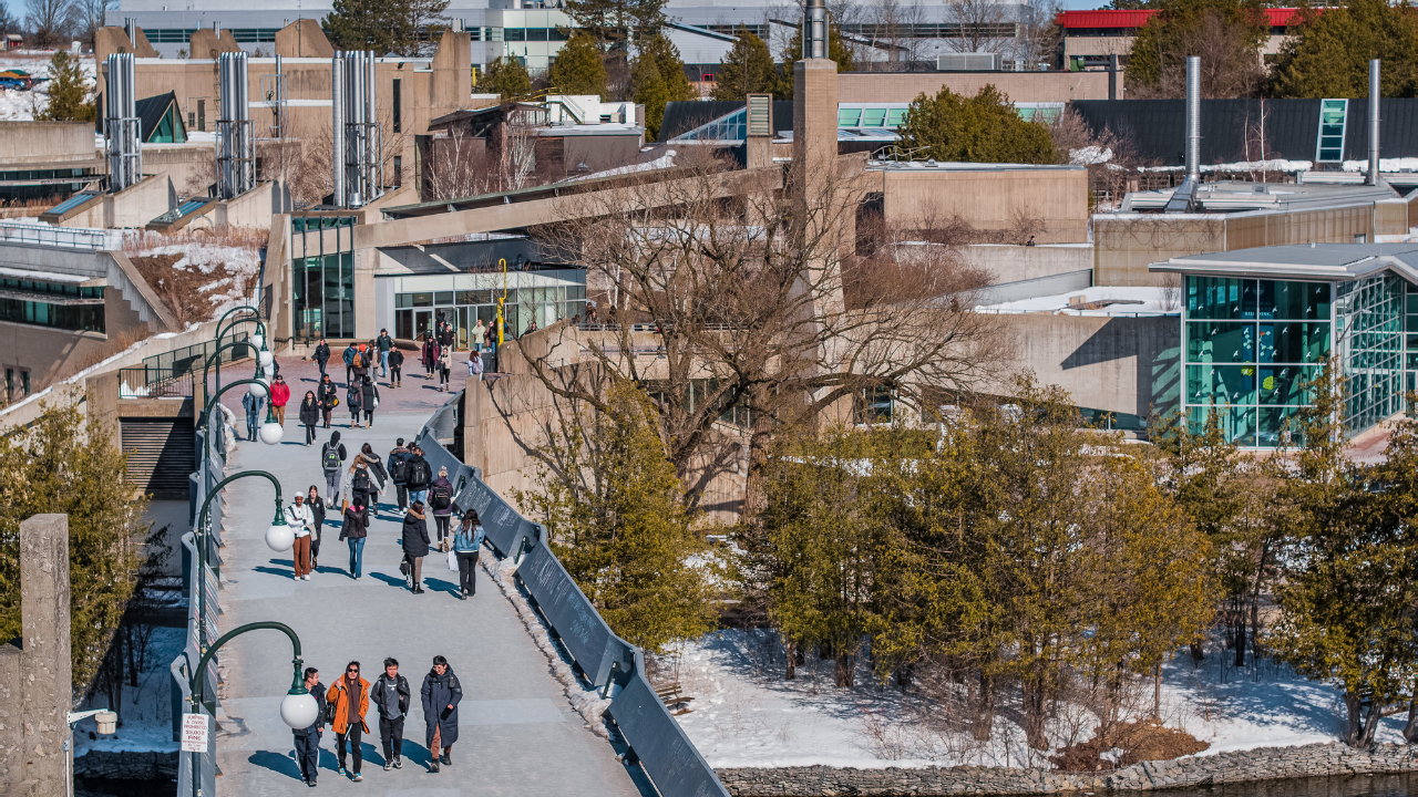 Aerial of students on the bridge in the winter.