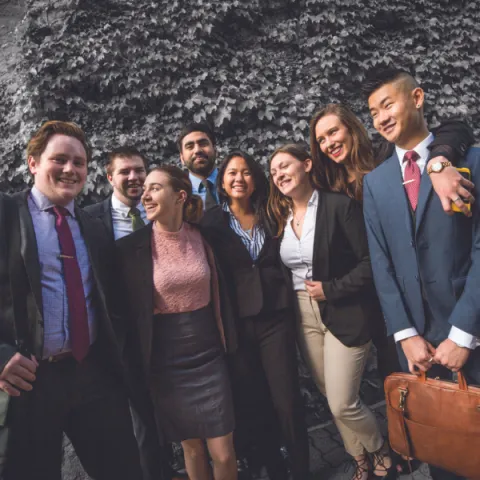 Group of Trent University students in business attire, laughing with each other.