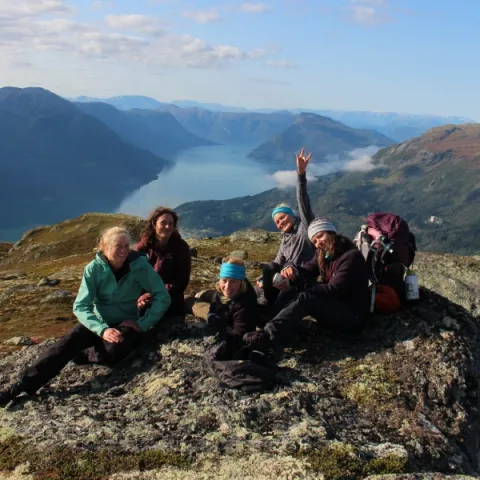 Trent University students on a study abroad program, sitting on top of a mountain, smiling at the camera.