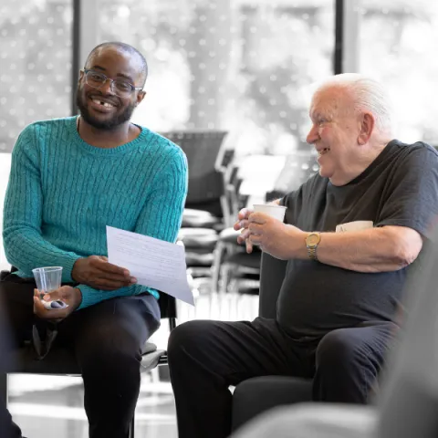 A student and a senior laughing with each other.