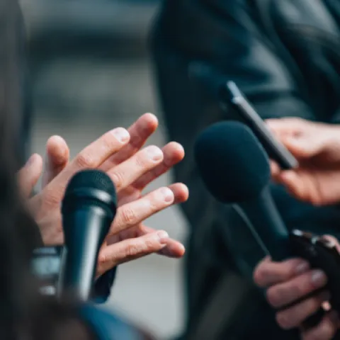 Interviewing business person at a press conference.