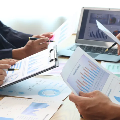 Close up of hands of business people working together in a conference room, brainstorming, discussing and analyzing and planning business strategies.