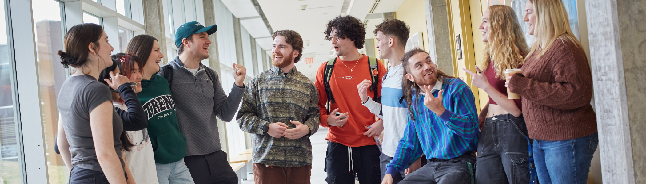 A Group of Trent University students talking to each other in a hallway.