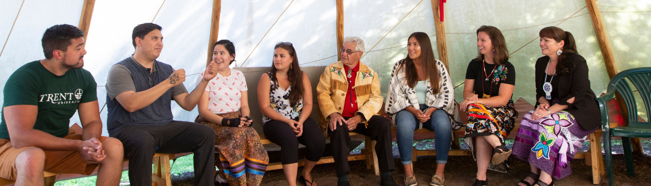 Group of Trent University First Peoples House of Learning staff and students talking inside of a tipi.