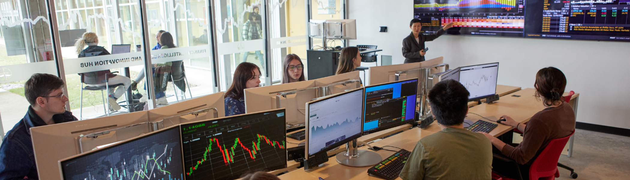 Lecture in Financial Intelligence & Innovation Hub, with students on computers looking at data.