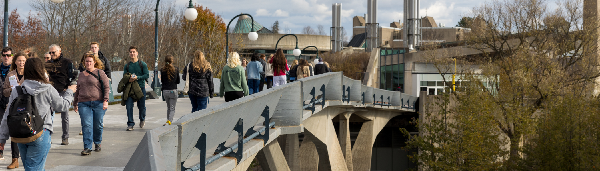 Groups of students and their families walking across the Faryon bridge during open house.