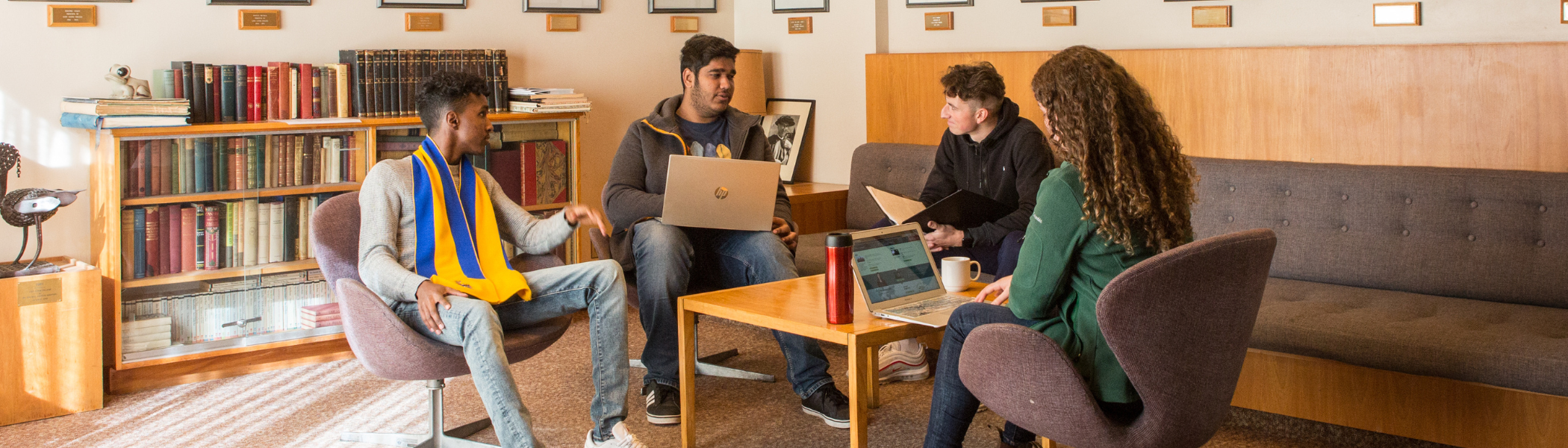 Four Trent students sitting around a table working on a project together.