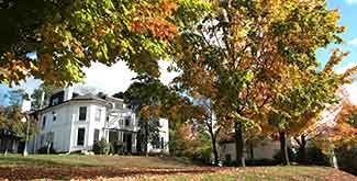 Outdoor view of Traill College in the autumn afternoon sun surrounded by autumn leaves