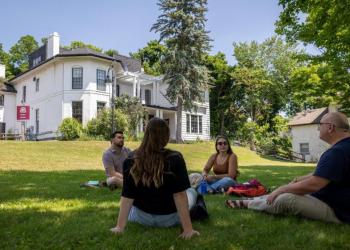 Group of students sitting outside Kerr House at Trent University