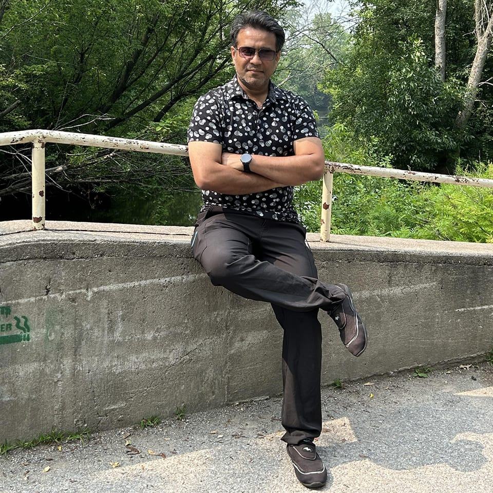 Profile picture of Nazmul Alam, smiling outside with trees in background