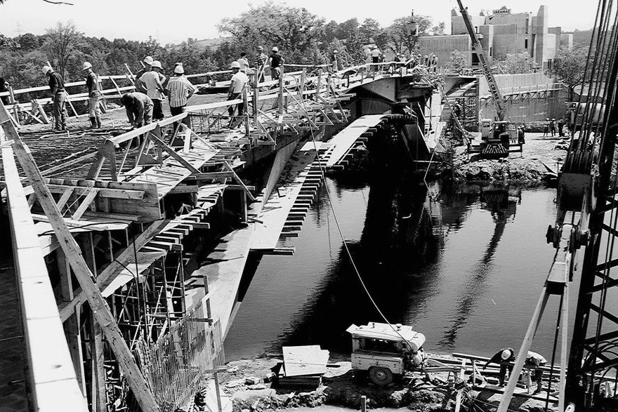 Black and white photograph of workers on a pedestrian bridge under construction