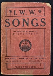 A book with a red cover and a lot of wear. The title is I.W.W. Songs to Fan the Flames of Discontent published by Industrial Workers of the World