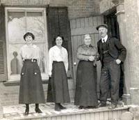 Black and white photograph of four people on a front step