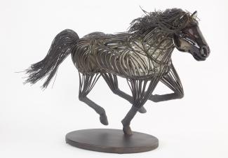Glass sculpture in the shape of a black horse, encapsulated in wire.