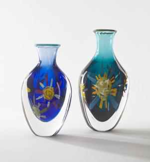 Two glass vases, painted blue with decorative suns. 